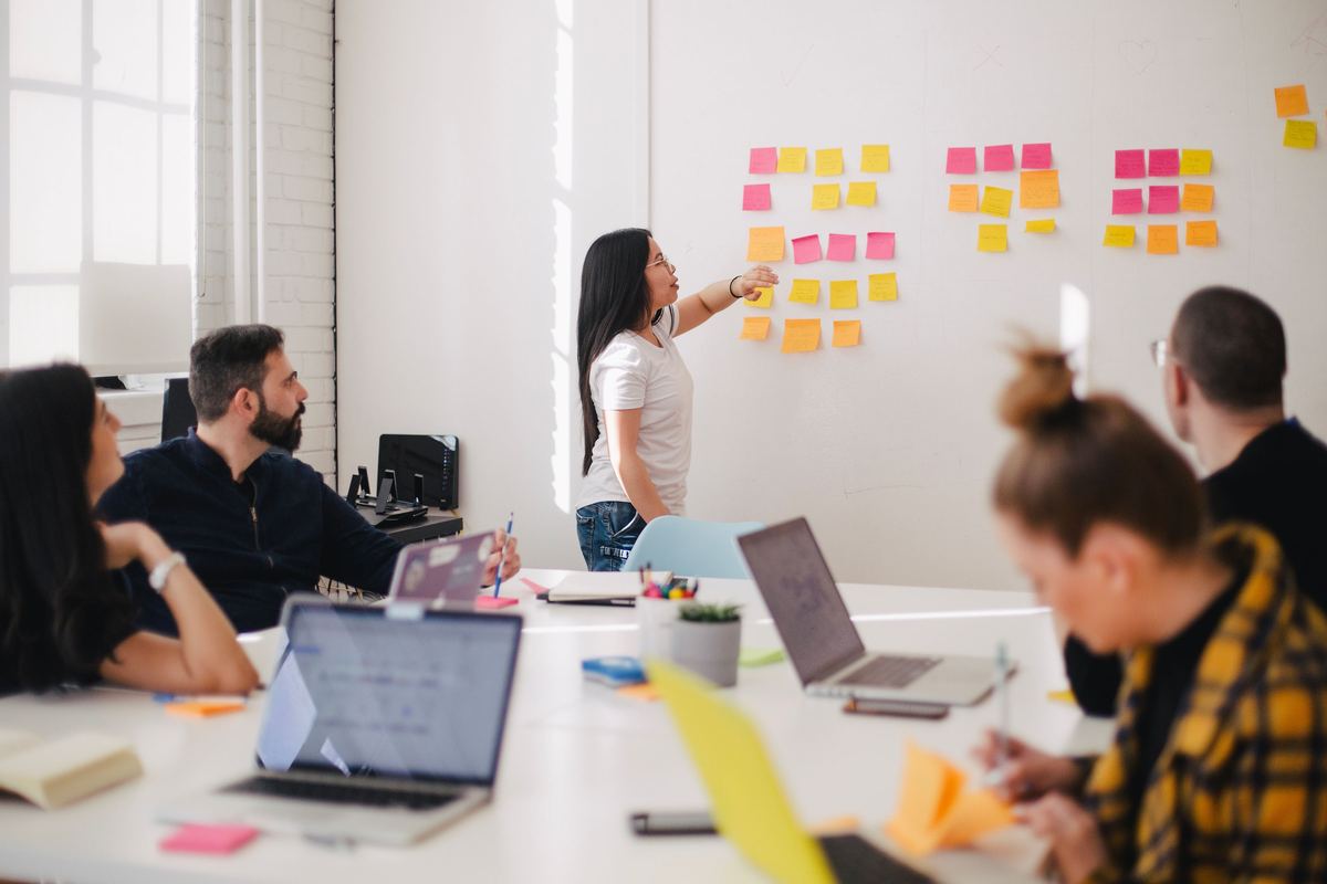 A team working through a wall of notes in a workshop